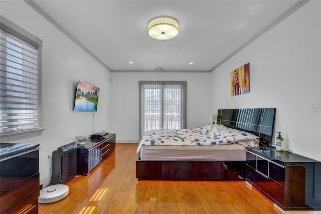 bedroom with baseboards, ornamental molding, and wood finished floors