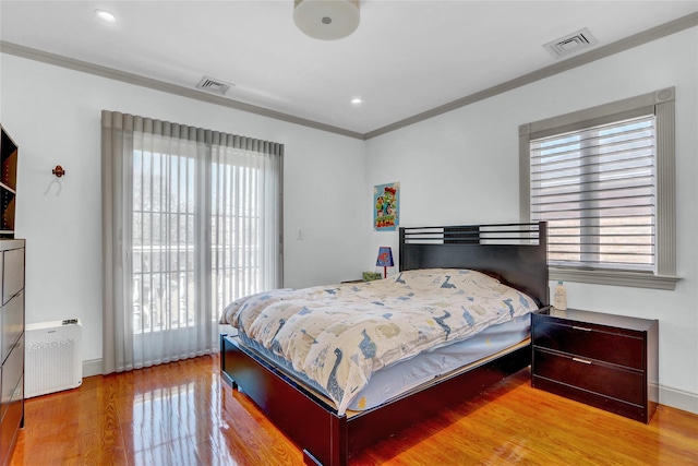 bedroom with multiple windows, visible vents, and crown molding