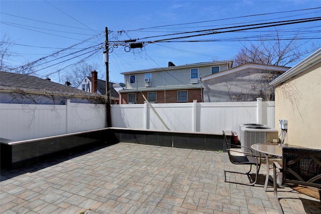 view of patio featuring a fenced backyard, cooling unit, and outdoor dining area