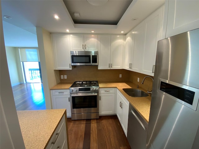 kitchen featuring stainless steel appliances, dark wood-style flooring, a sink, white cabinetry, and recessed lighting