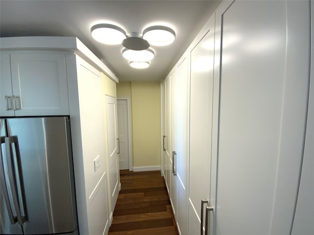 hallway with dark wood finished floors and baseboards