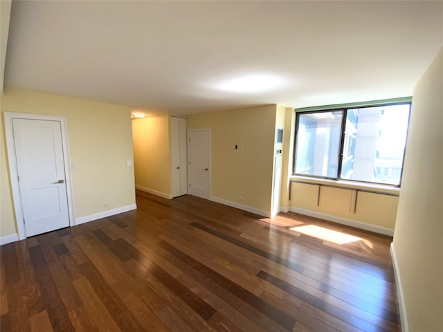 unfurnished room with wood-type flooring and baseboards