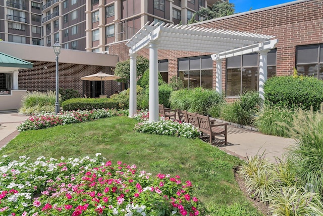 view of home's community with a pergola and a yard