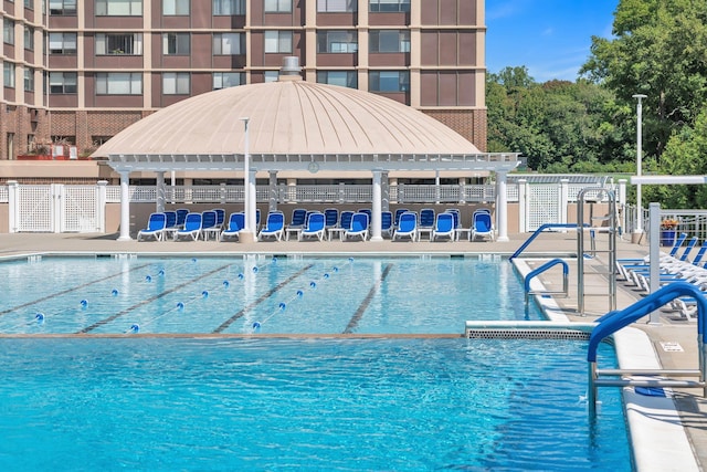 community pool featuring fence and a patio area