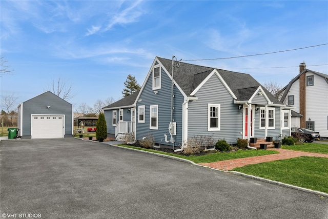 4100 Youngs Ave, Southold, NY 11971 - view of front of house with an outdoor structure, a front lawn, roof with shingles, driveway, and a detached garage