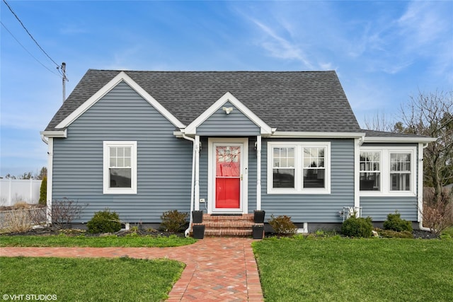 4100 Youngs Ave, Southold, NY 11971 - view of front facade with fence, a shingled roof, entry steps, and a front lawn