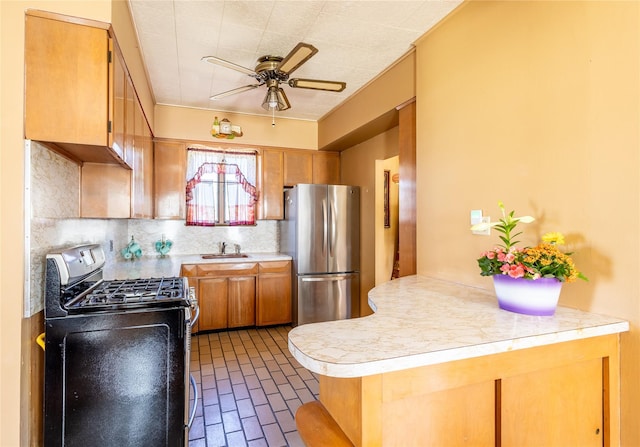 675 N Oakwood Rd, Laurel, NY 11948 - kitchen with stainless steel appliances, a peninsula, a sink, ceiling fan, and light countertops