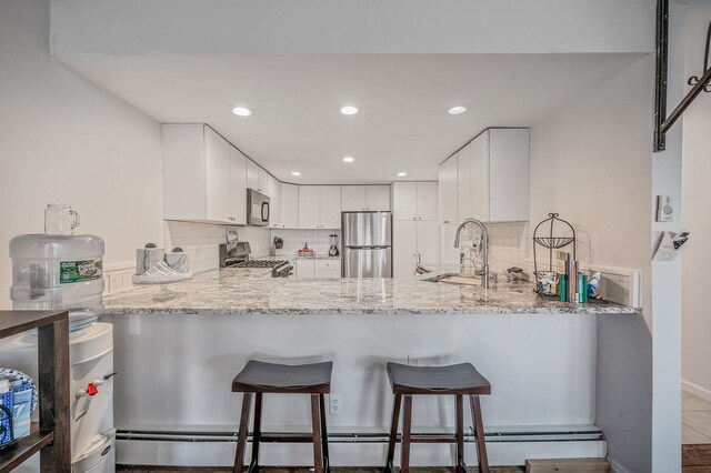 19 Hillside Ave, Northport, NY 11768 - kitchen with freestanding refrigerator, black microwave, stove, a sink, and a peninsula
