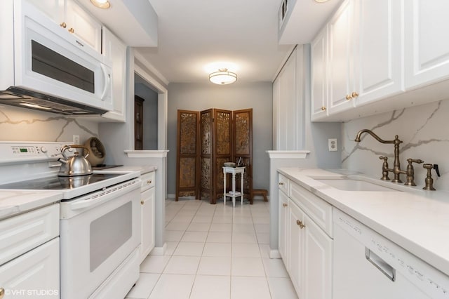 kitchen featuring a sink, light countertops, white appliances, white cabinetry, and light tile patterned flooring