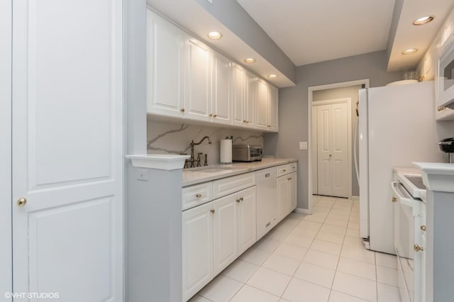 kitchen featuring light countertops, recessed lighting, white cabinetry, and a sink