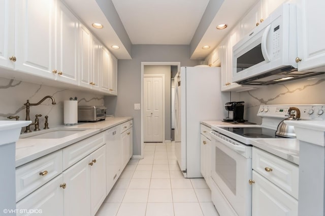 kitchen with white cabinetry, a sink, white appliances, and recessed lighting