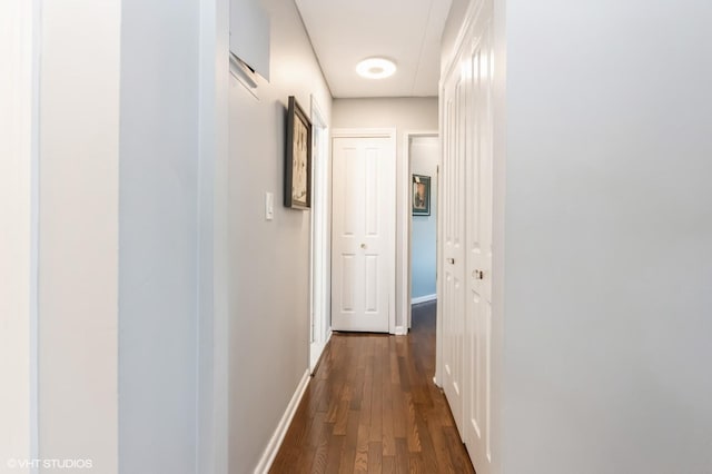 hallway featuring dark wood-style floors and baseboards