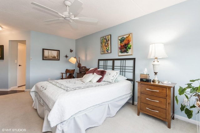bedroom with ceiling fan, light colored carpet, and baseboards
