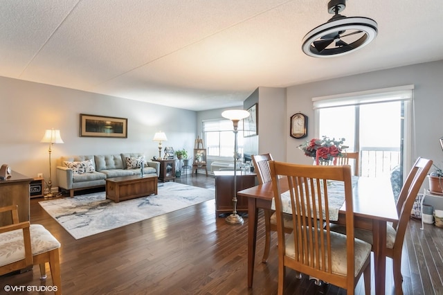 dining area with a textured ceiling and dark wood finished floors