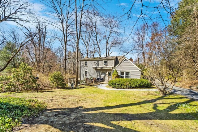 65 Hickory Ln, Bedford, NY 10506 - back of property featuring a wooden deck, a yard, and a chimney