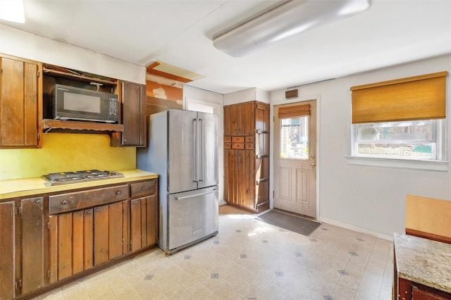 65 Hickory Ln, Bedford, NY 10506 - kitchen with light countertops, baseboards, brown cabinetry, and stainless steel appliances