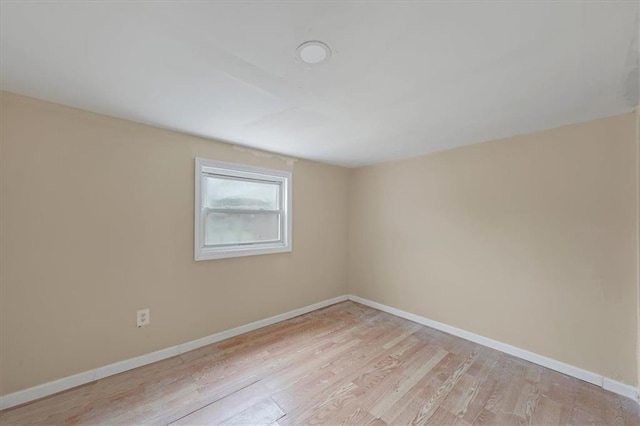 unfurnished room with light wood finished floors and baseboards