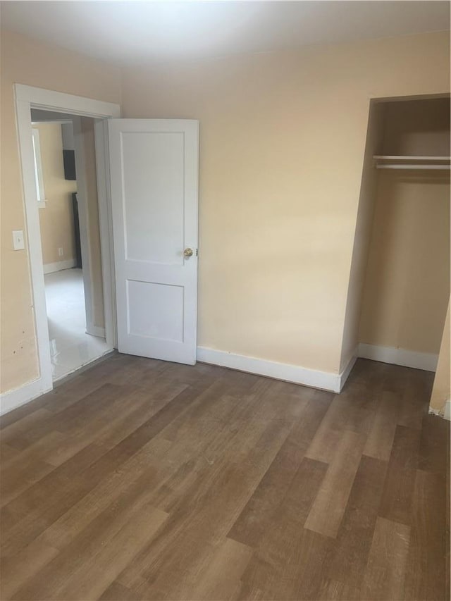 unfurnished bedroom featuring a closet, baseboards, and wood finished floors