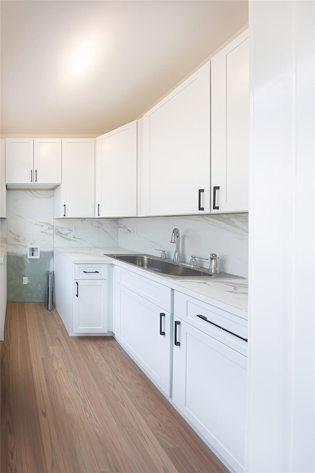 3 Carlton Rd Unit 201, Monsey, NY 10952 - kitchen with white cabinetry, decorative backsplash, light wood-style flooring, a sink, and light countertops