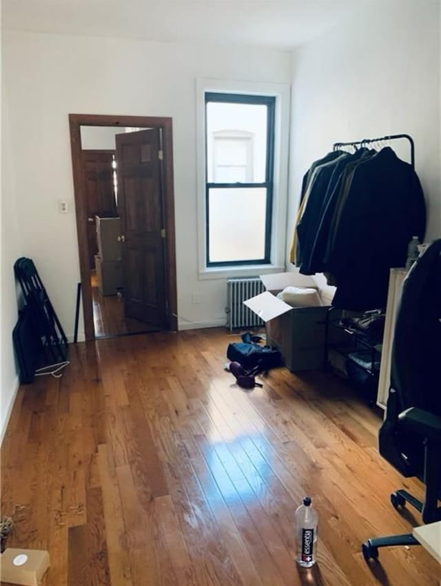 bedroom featuring hardwood / wood-style flooring and radiator