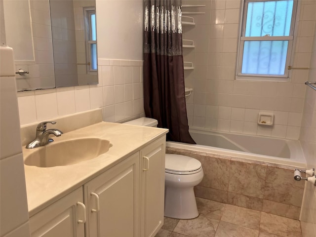 bathroom with tile walls, toilet, tiled shower / bath combo, and vanity