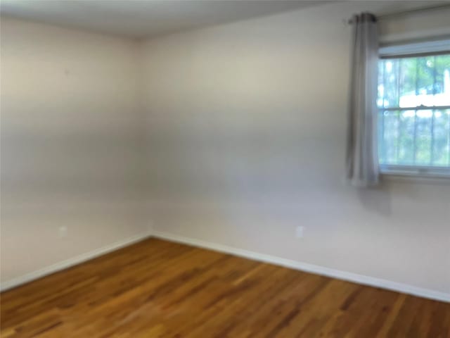 empty room featuring baseboards and wood finished floors