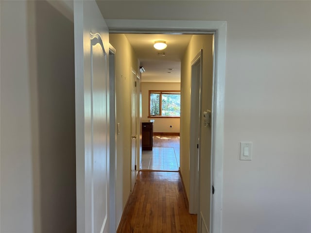 hallway with baseboards and dark wood-style flooring