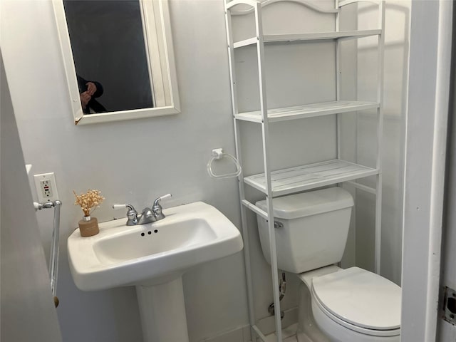 half bath featuring toilet and a sink