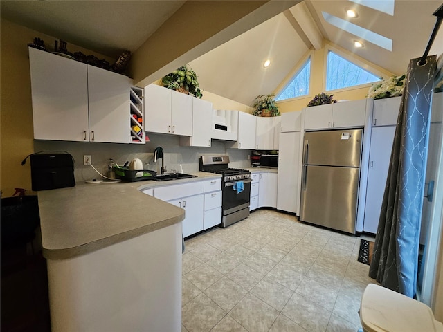 kitchen featuring light countertops, beam ceiling, stainless steel appliances, and a sink