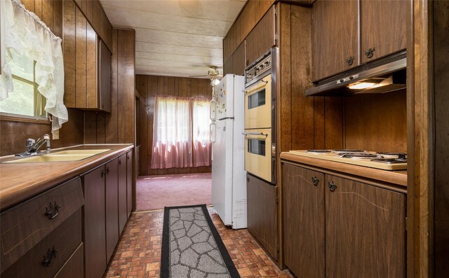126-128 Christian Hill Rd, Dover Plains, NY 12522 - kitchen with white appliances, brick patterned floors, under cabinet range hood, light countertops, and wooden walls