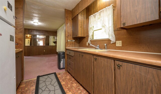 126-128 Christian Hill Rd, Dover Plains, NY 12522 - kitchen featuring wood walls, light countertops, brick patterned floors, and brown cabinets