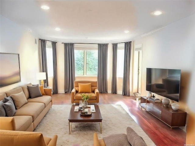 living area with recessed lighting, wood finished floors, and ornamental molding