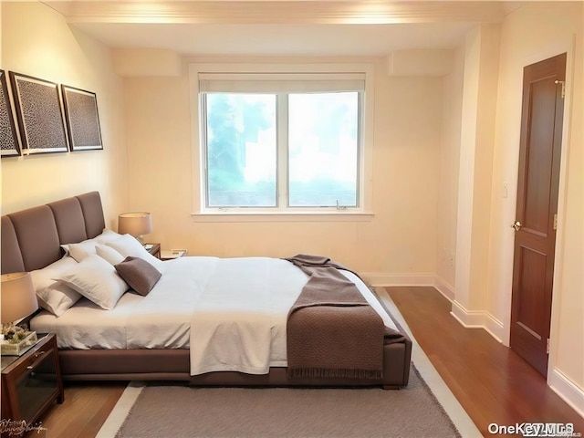 bedroom with baseboards and wood finished floors