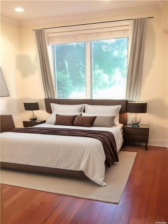 bedroom featuring baseboards, recessed lighting, wood finished floors, and ornamental molding