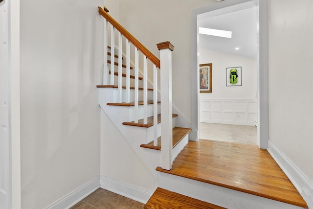 stairs featuring baseboards and vaulted ceiling