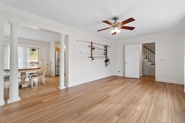 unfurnished room with crown molding, stairway, a ceiling fan, and light wood finished floors