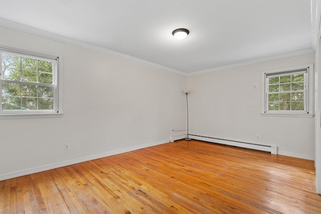 empty room with baseboards, ornamental molding, a baseboard heating unit, and light wood-type flooring