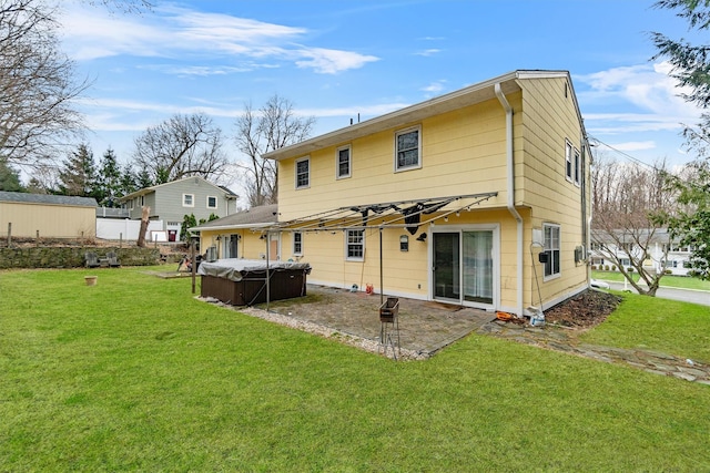 rear view of house featuring a yard, a patio area, and a hot tub