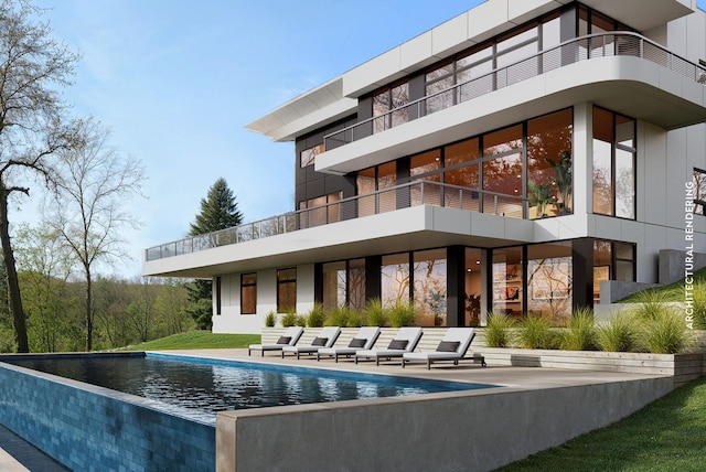 rear view of house with an outdoor pool and a patio