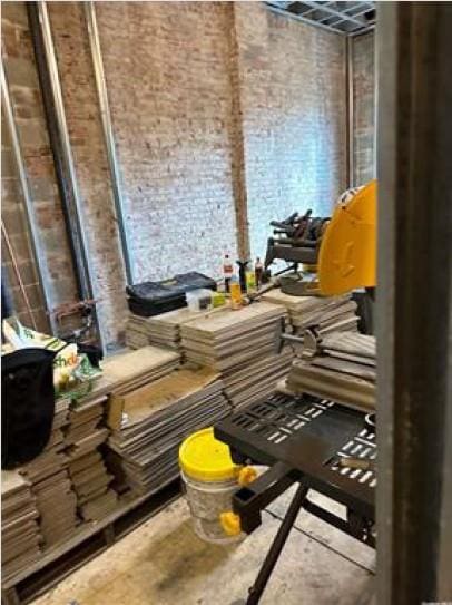 miscellaneous room featuring concrete flooring and brick wall