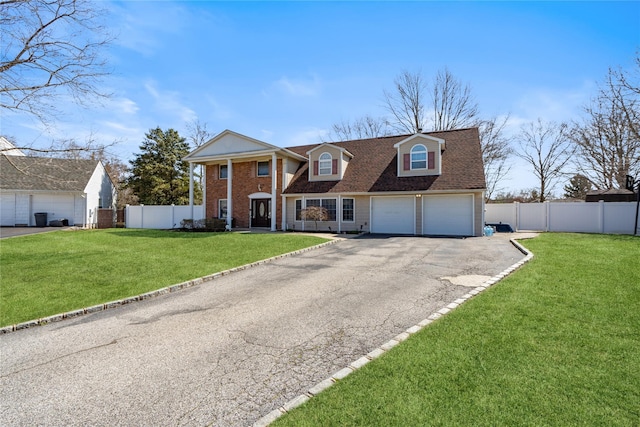 view of front facade featuring an attached garage, driveway, fence, and a front lawn