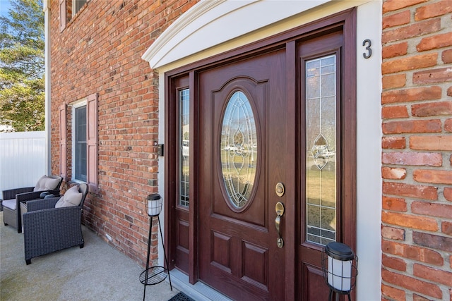 view of exterior entry featuring brick siding