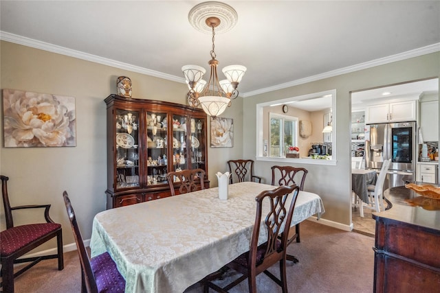carpeted dining room featuring baseboards, crown molding, and a notable chandelier