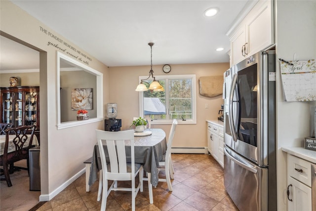 kitchen with hanging light fixtures, white cabinets, stainless steel fridge, and light countertops