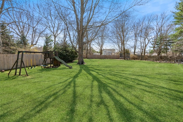 view of yard featuring a fenced backyard and a playground