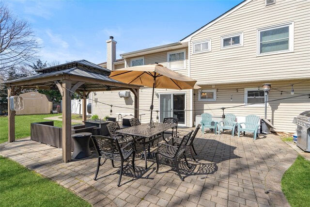 view of patio featuring outdoor dining area, a gazebo, a grill, an outdoor structure, and a shed
