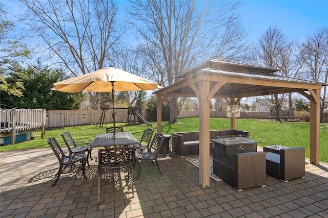 view of patio / terrace with an outdoor fire pit, a fenced backyard, outdoor dining area, and a playground