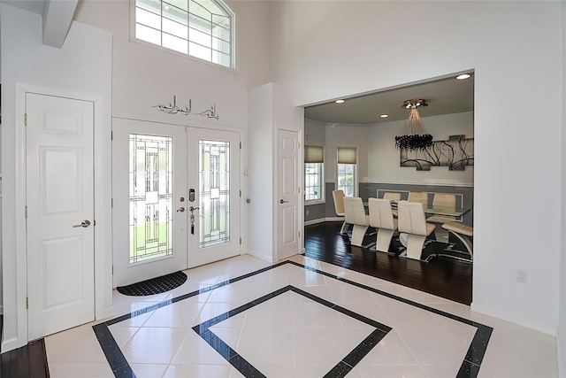 foyer with inlaid floor details, french doors, baseboards, a high ceiling, and recessed lighting