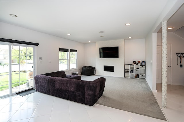 living room featuring recessed lighting, light tile patterned floors, light colored carpet, and a large fireplace