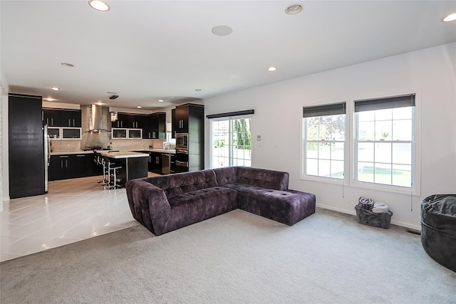 living area featuring light colored carpet, recessed lighting, and baseboards